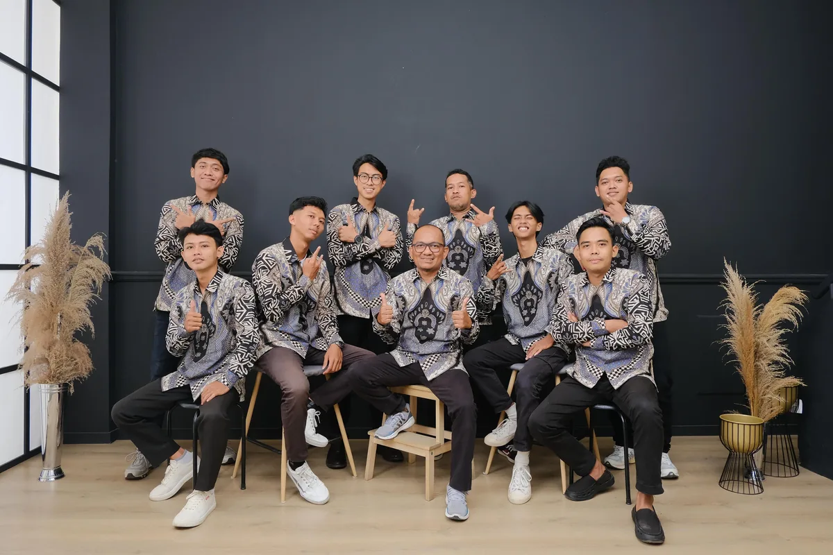 Sekelompok pria mengenakan kemeja batik seragam bermotif monokrom dalam pemotretan studio