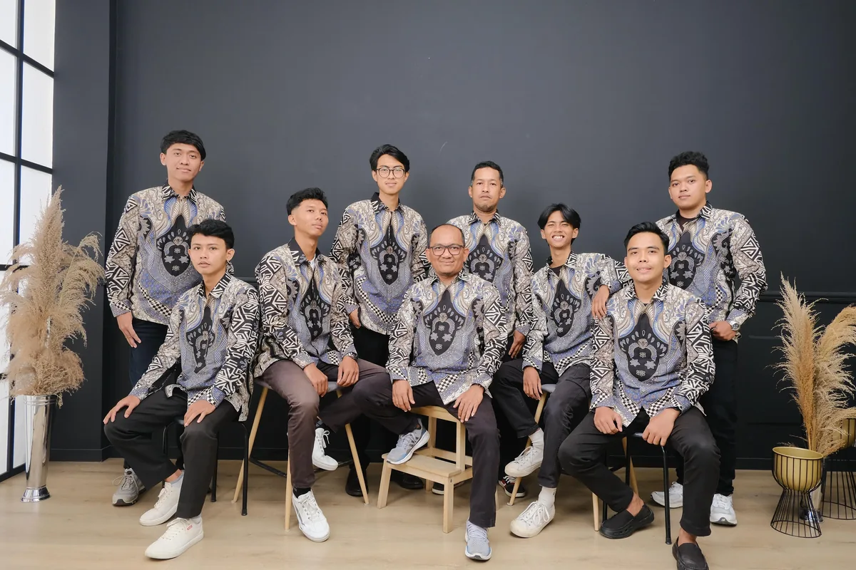 Anggota komunitas berpose dengan kemeja batik seragam berwarna abu bermotif