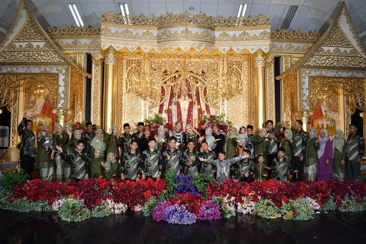 Panitia pernikahan adat Jawa mengenakan batik seragam di depan pelaminan